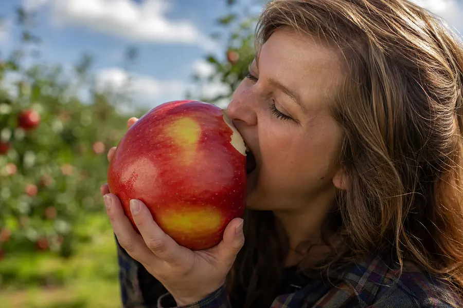 genere moi une image d'une personne qui mange une grosse pomme
