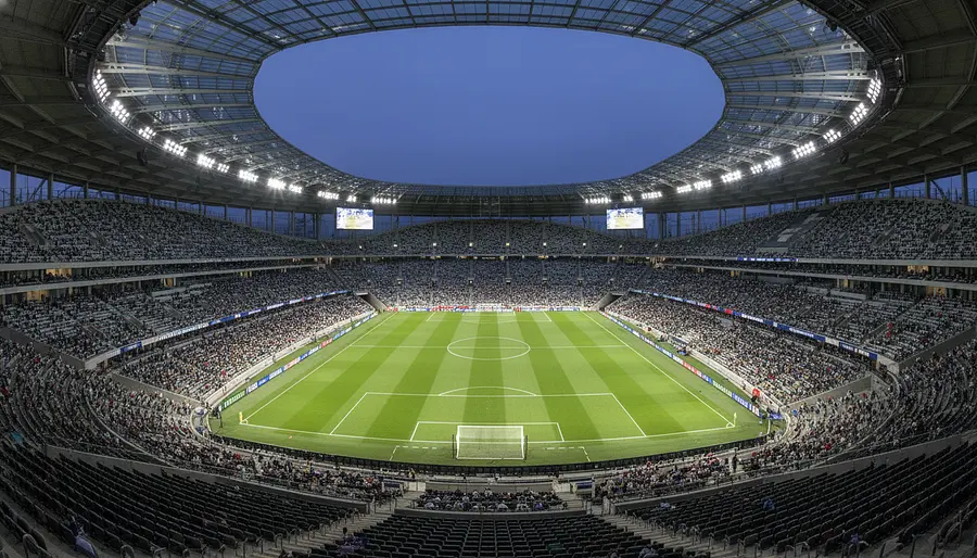 Erstelle ein beeindruckendes, fotorealistisches Bild eines riesigen modernen Fußballstadions, ins...